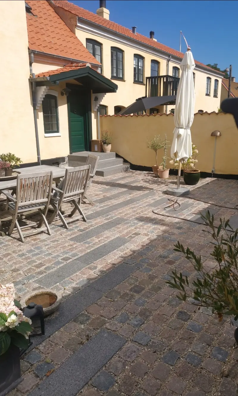 Granitbelægning med brosten lagt i bueforband til indkørsel