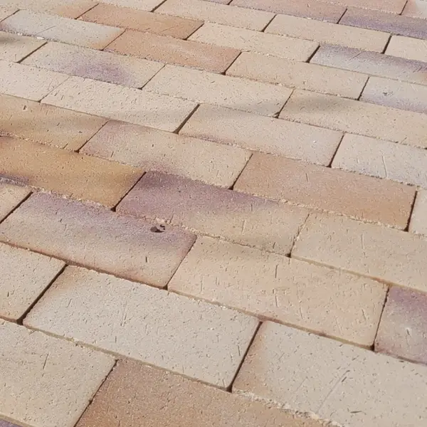 Nærbillede af nylagt belægning i store beige og brune belægningssten